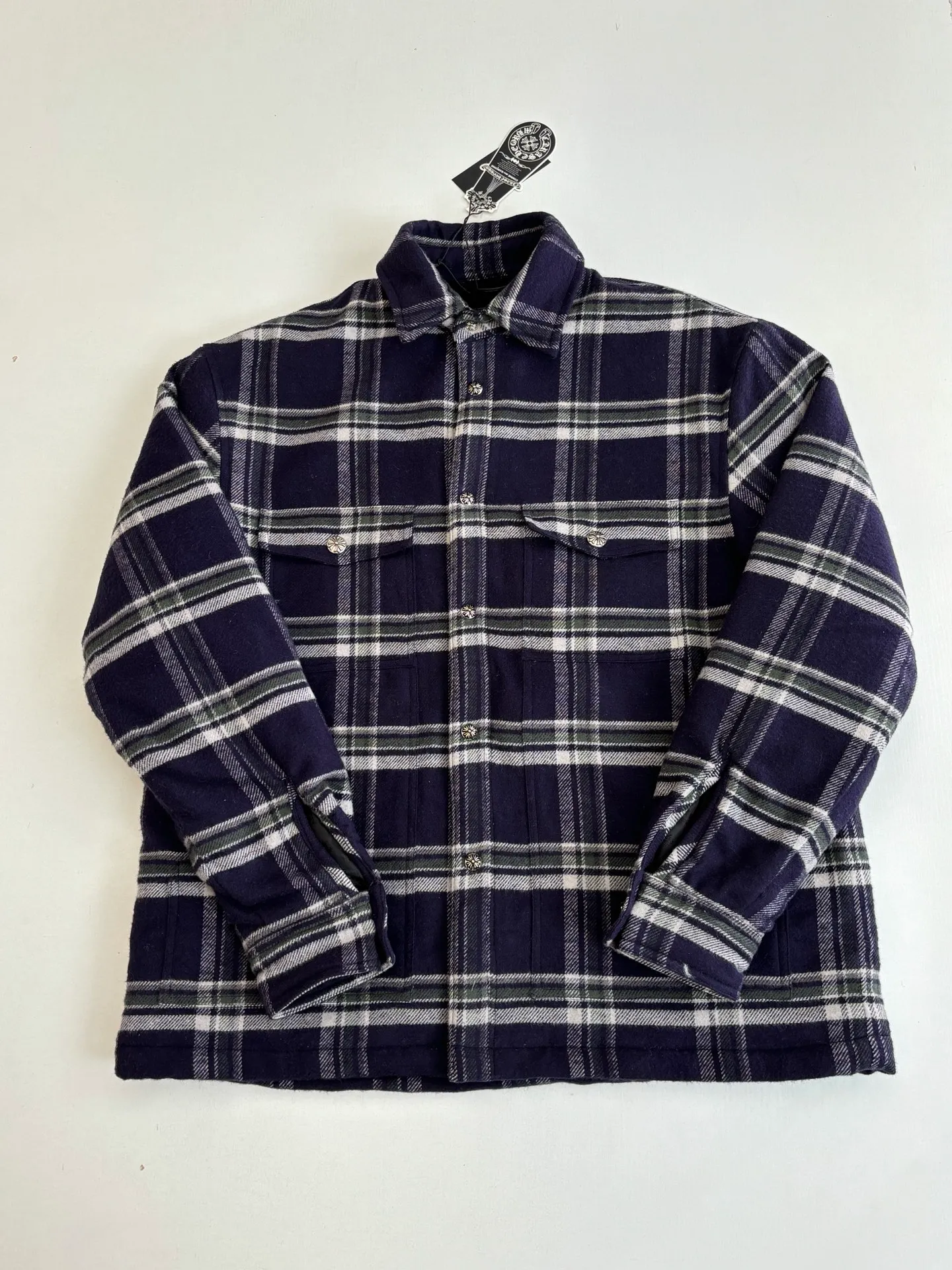 P670 Chrome Heart*/Chrome Heart Contrast Plaid Lapel Shirt Jacket. The fabric is made of 100% cotton fabric to create a navy blue main tone plaid. The rough plaid lines blend into the brand's iconic Gothic rebellious gene. The stiff cotton material supports the street silhouette, and the plush fabric inside adds softness and warmth. The collision of cold silver hardware and soft and warm inner wear is the dark aesthetic of Chrome Hearts' "symbiosis of hard core and gentleness". The autumn and winter layering has its own rock and roll accent.  Size：S/M/L/XL